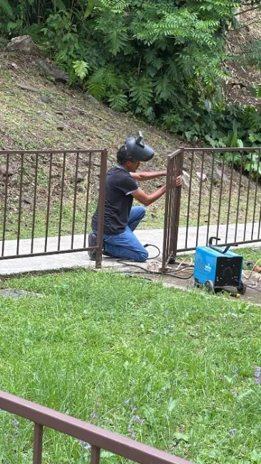 Operario instalando y soldando rejas metálicas de protección en exteriores
